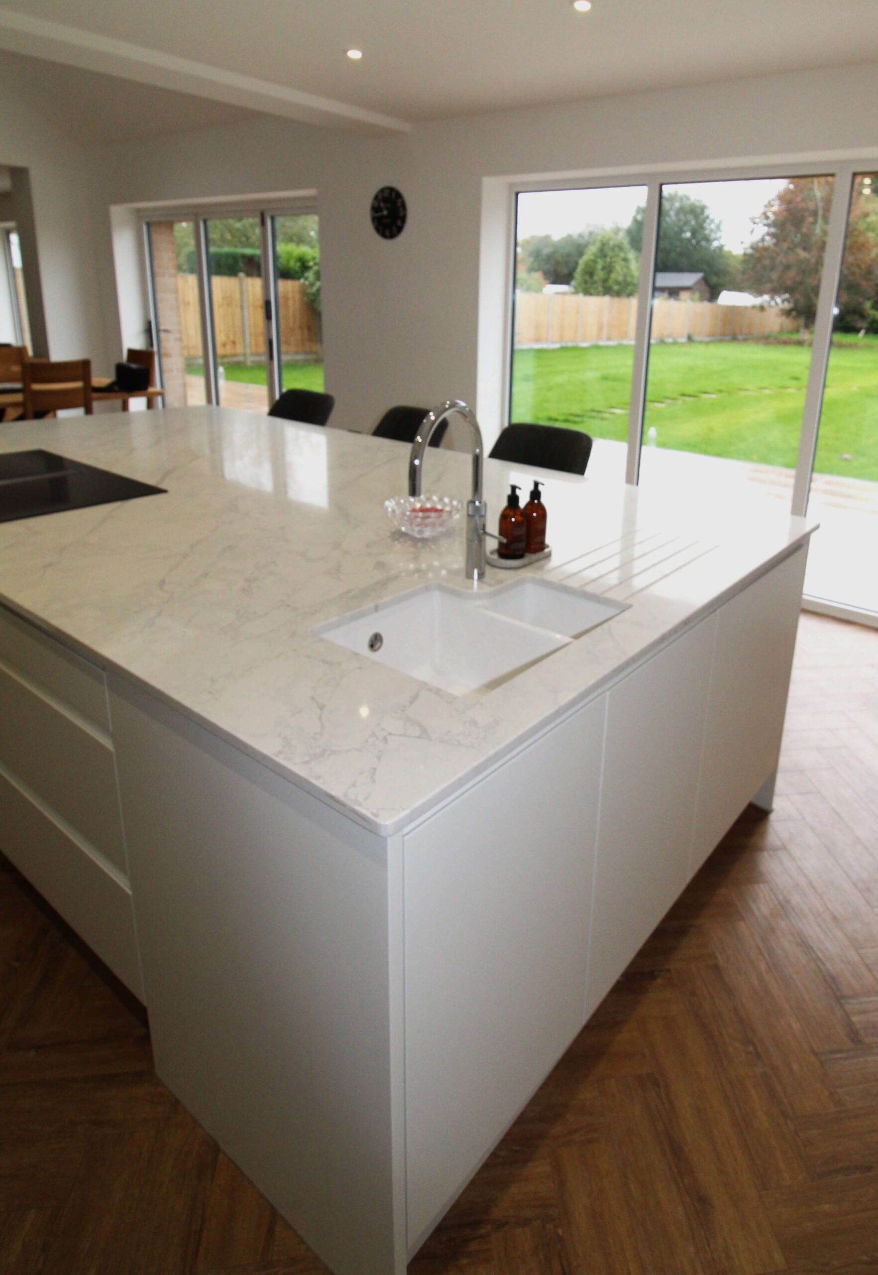 Handle-less slab kitchen island with ceramic undermount sink and quooker tap