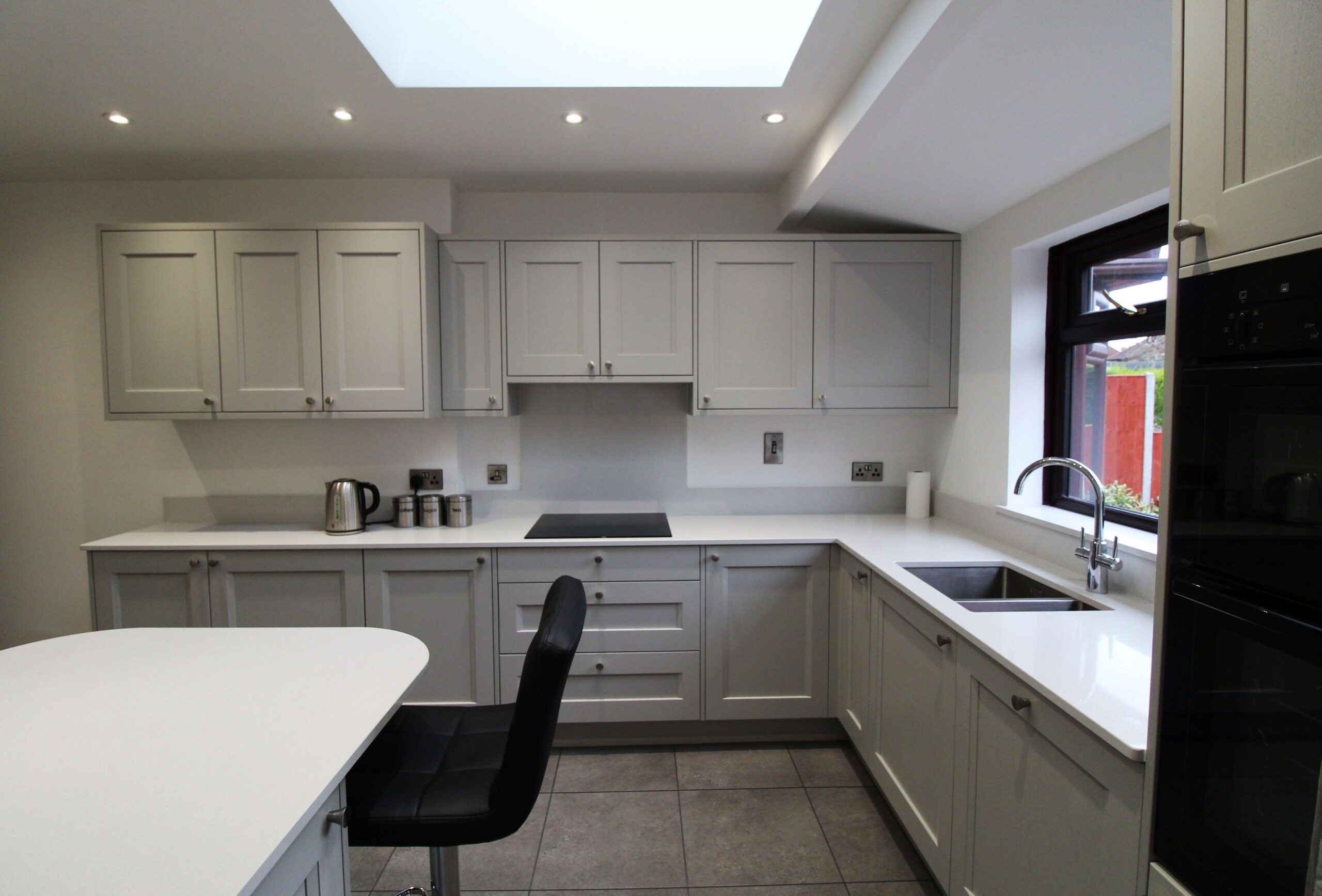 Soft grey shaker kitchen with black barstool