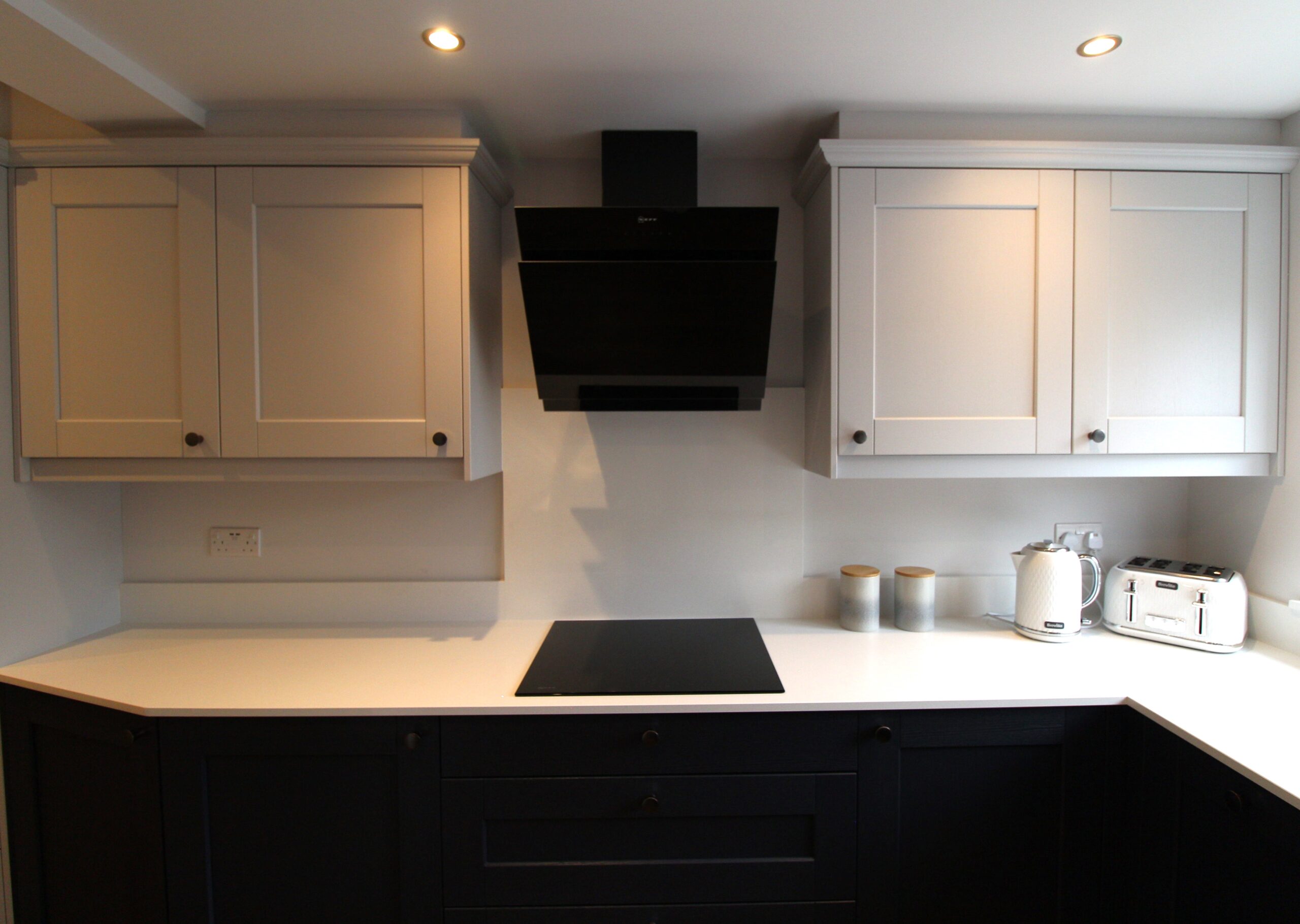 blue and light grey shaker kitchen with neff induction hob and neff extractor and white quartz worktop