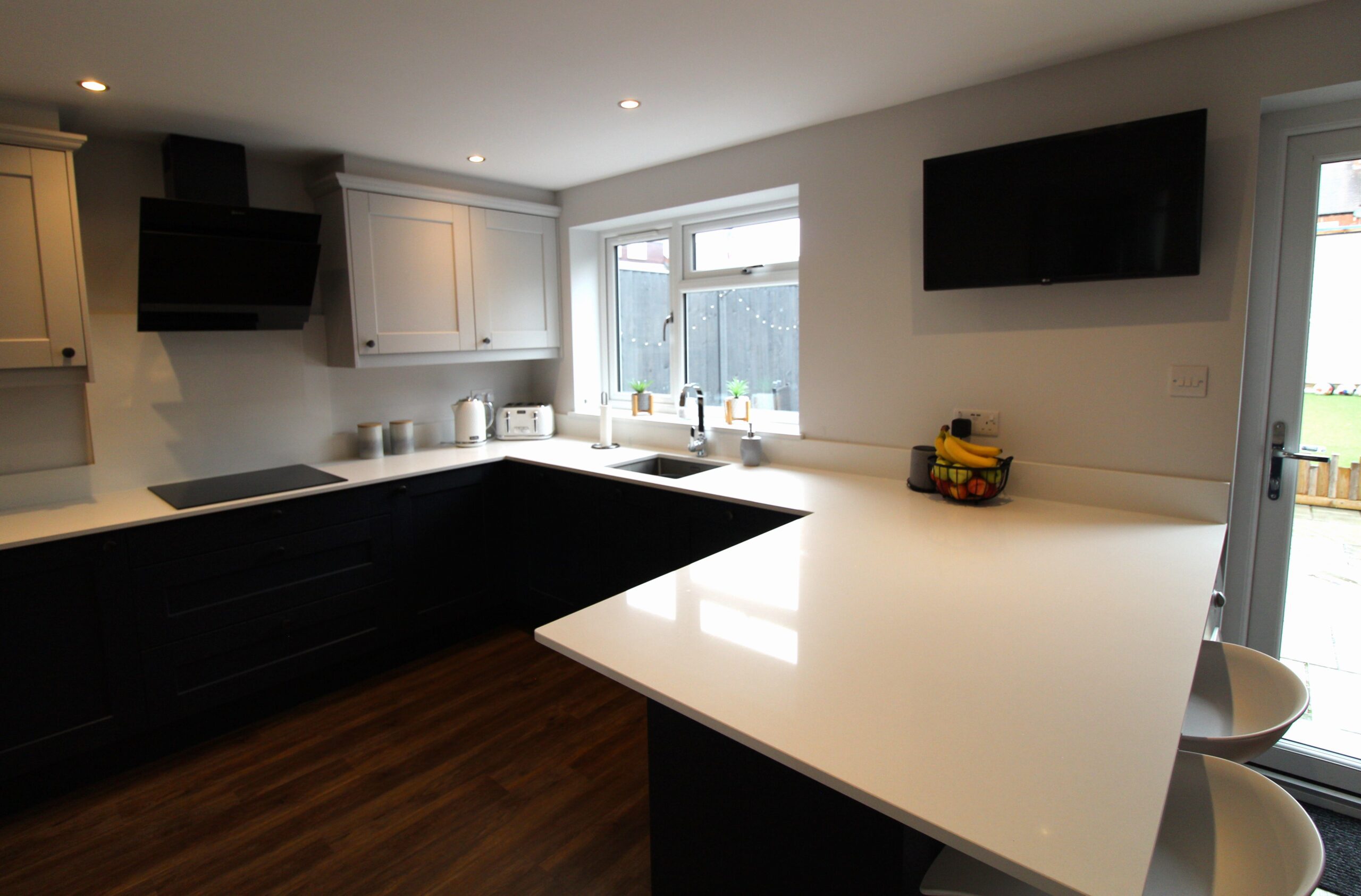 blue and light grey shaker kitchen whic white quartz worktop stainless steel sink and chrome tap