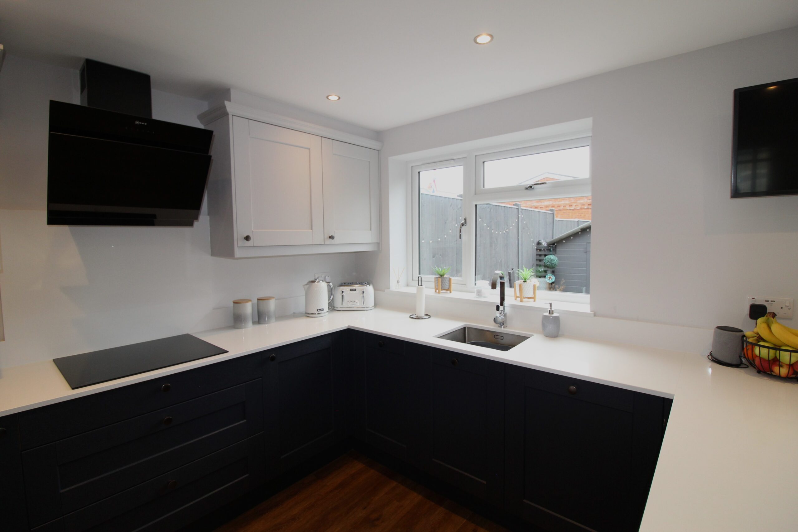 light grey and blue shaker kitchen with white quartz worktop