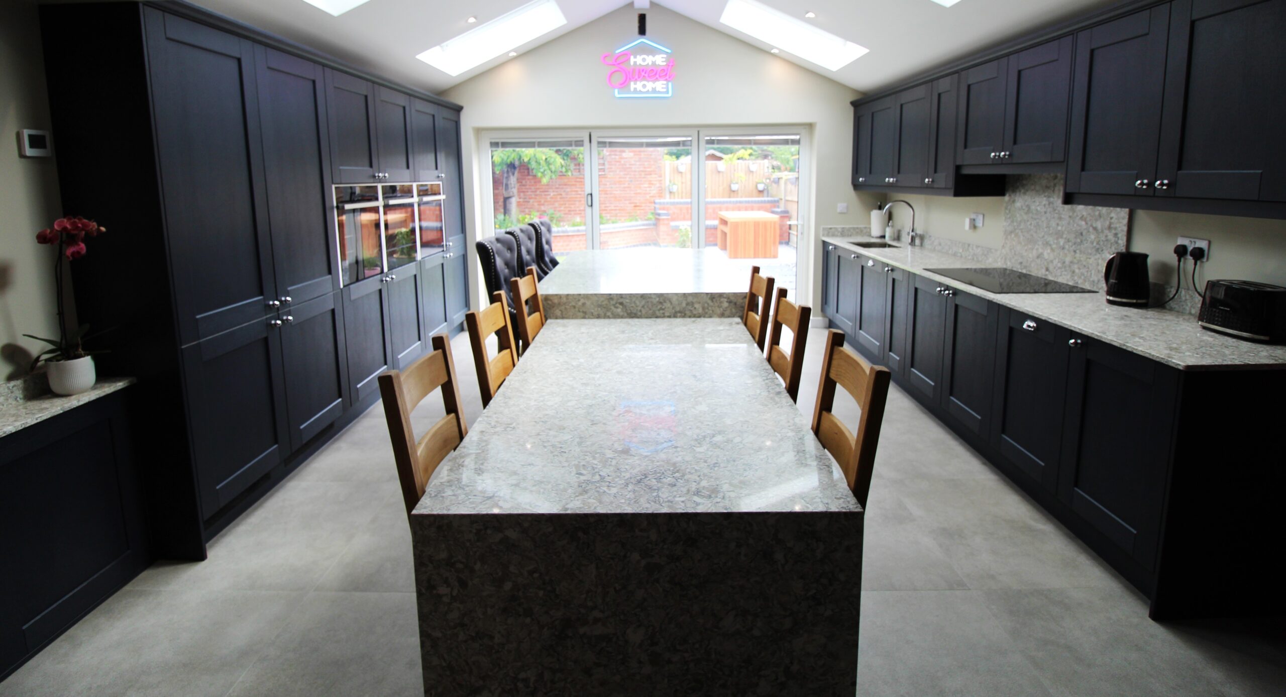 blue vinyl shaker kitchen with quartz worktop on centre island