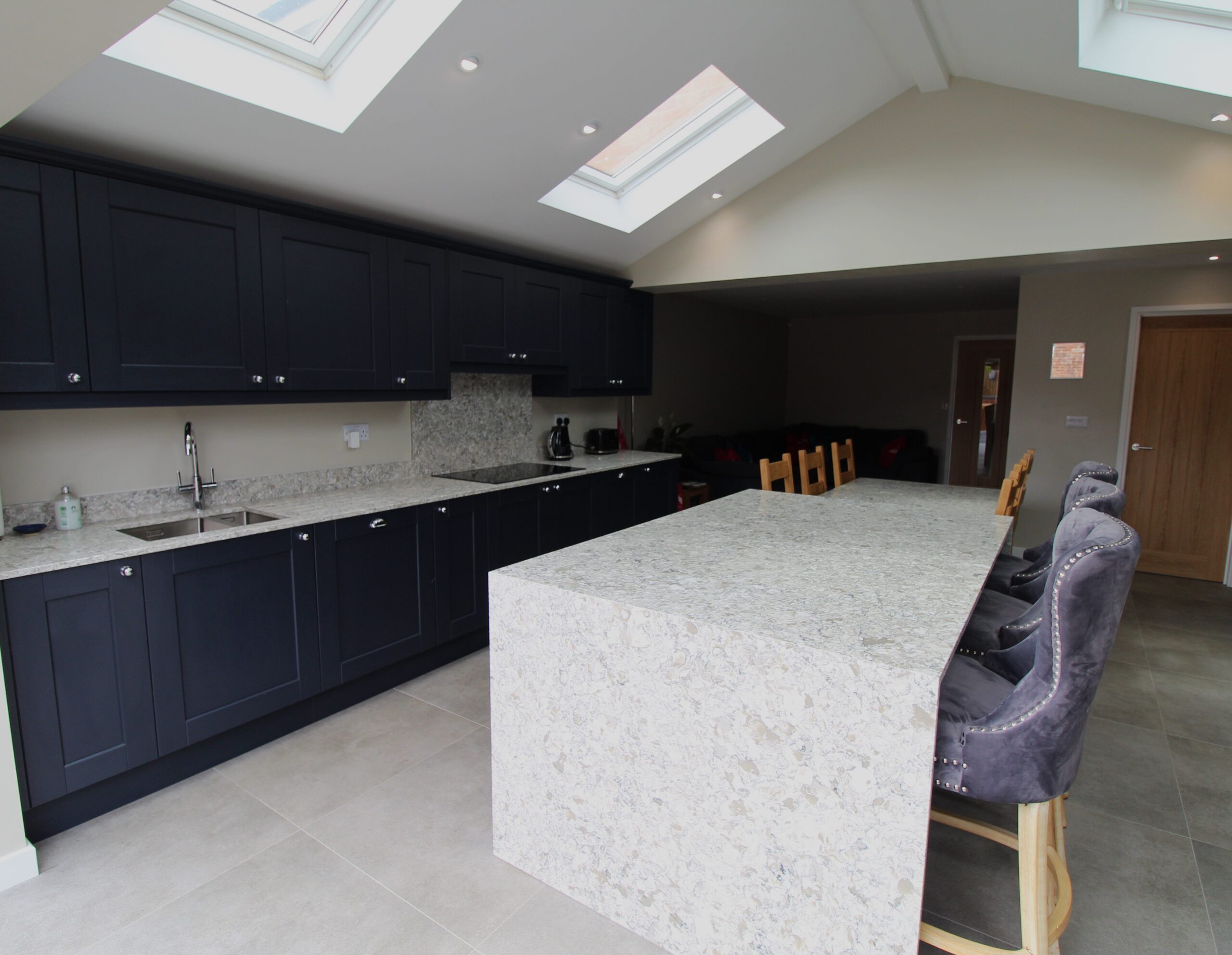 blue vinyl shaker kitchen with quartz worktop on centre island