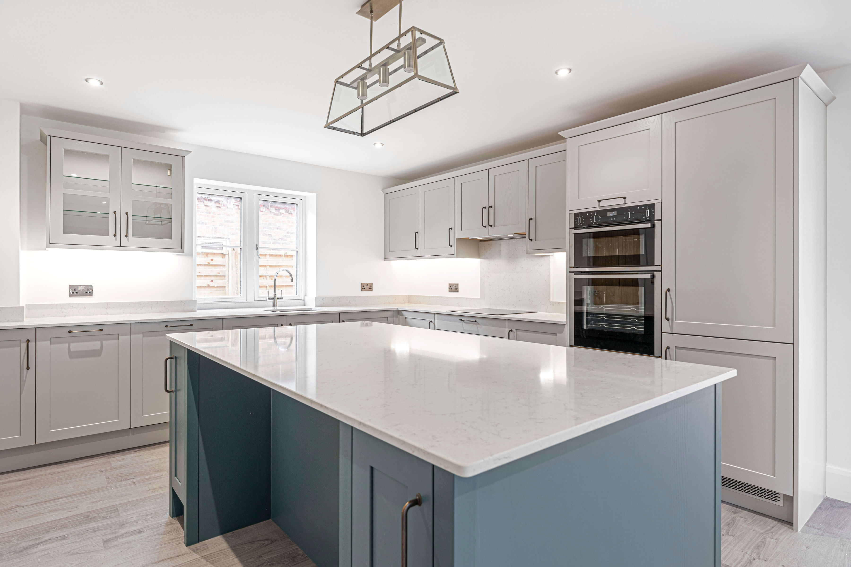 grey shaker kitchen cabinets with blue shaker kitchen island and white quartz worktop
