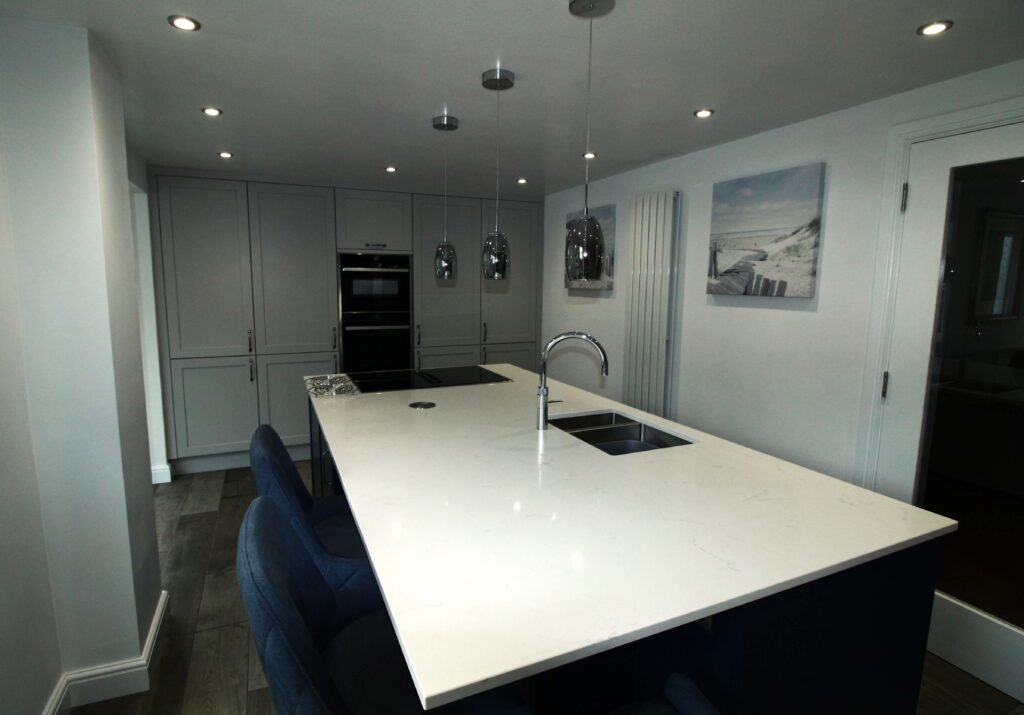 Shaker kitchen island in blue with downdraft induction hob and quartz worktop