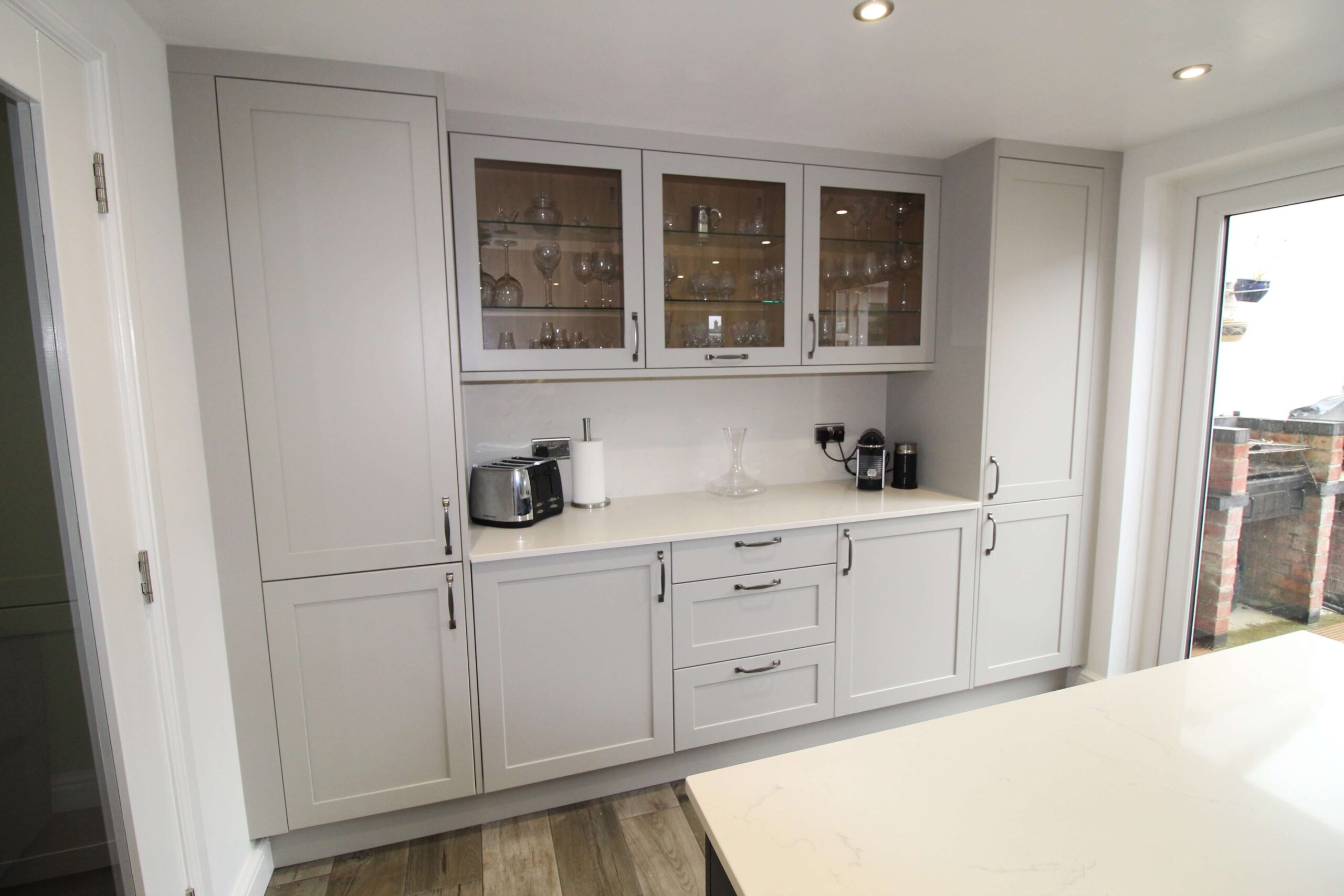 Soft grey shaker kitchen units with glass doors