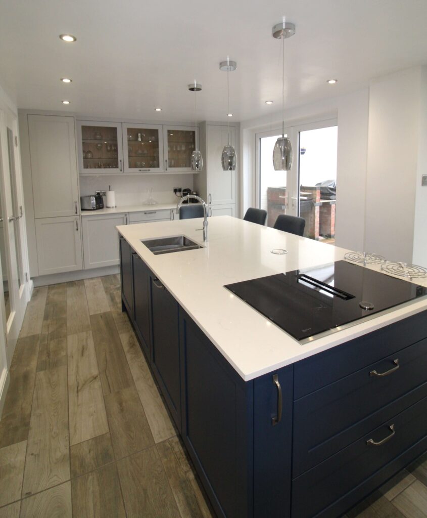 Fenton shaker door in prussian blue presented on a kitchen island with neff downdraft extractor, inset stainless steel sink and quooker tap