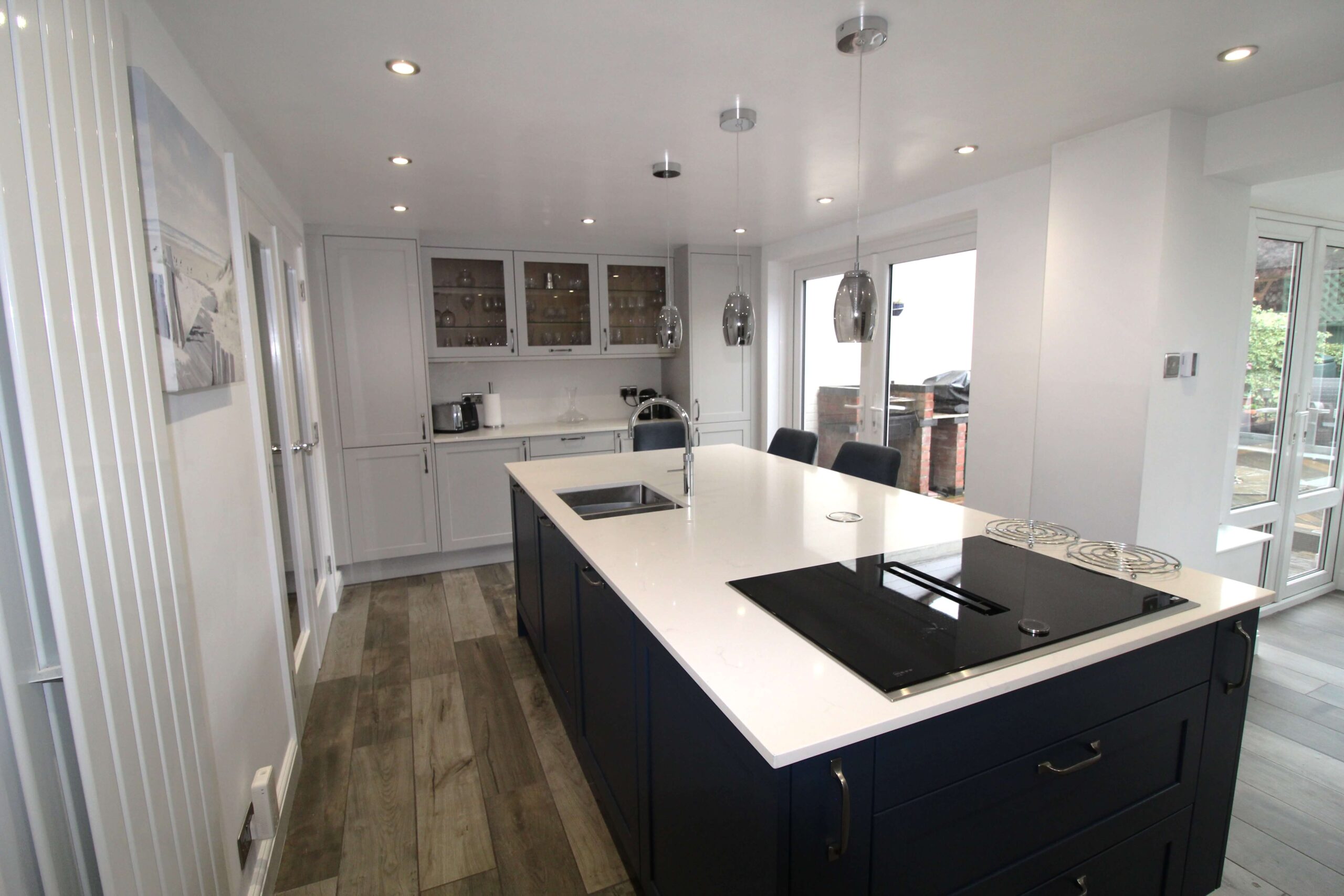 Shaker kitchen island in blue with downdraft induction hob and quartz worktop