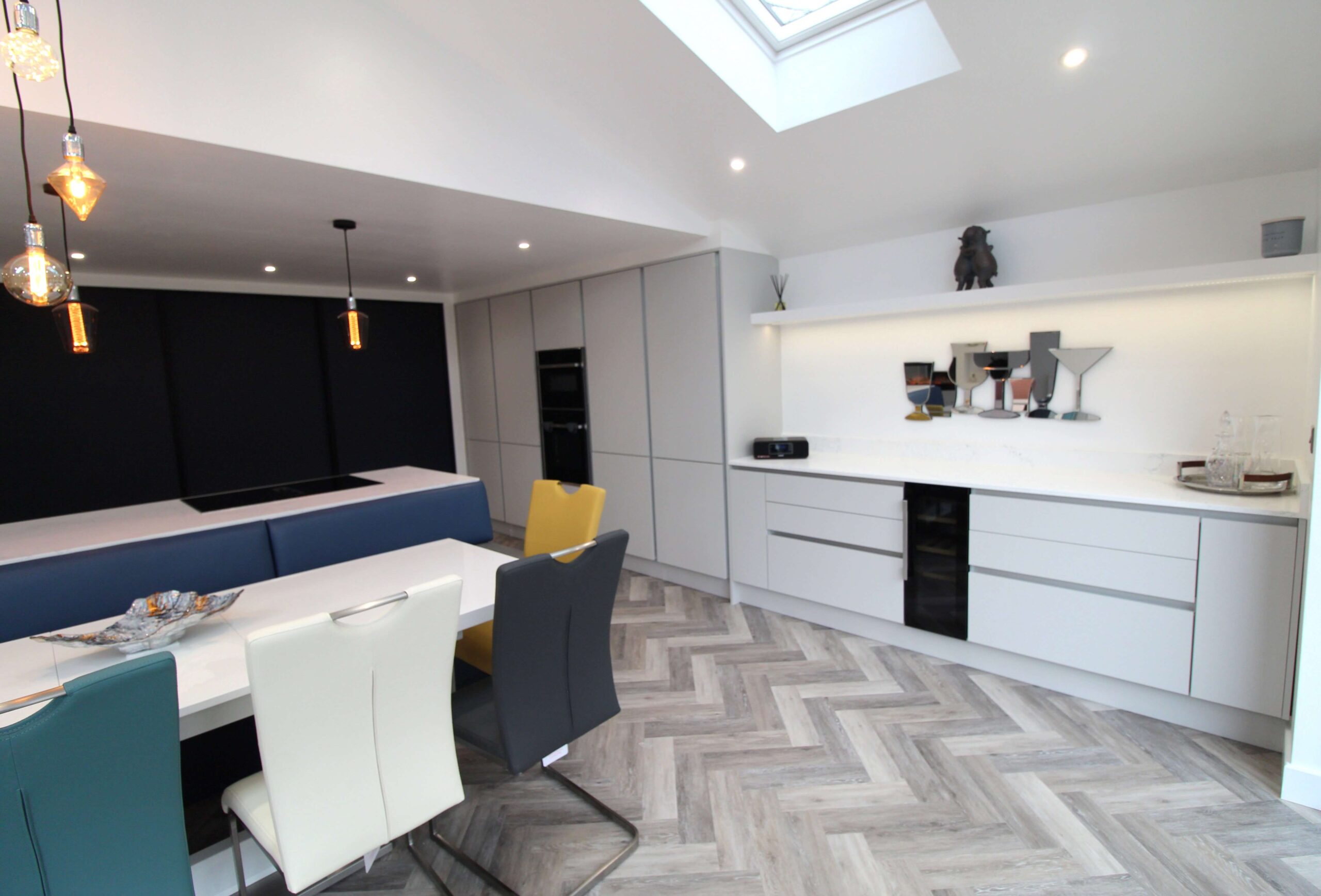 grey handle-less slab kitchen in light grey with blue slab sliding doors