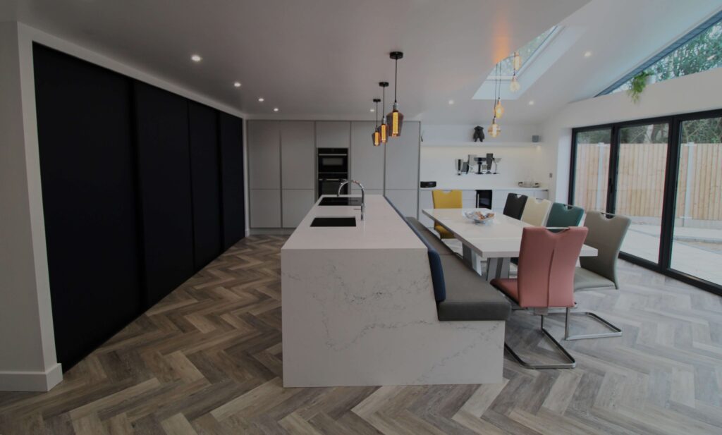 blue slab door with quartz kitchen island and pastel coloured seating around dining table