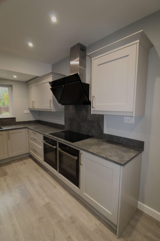 soft grey shaker kitchen with concrete quartz worktop and neff induction hob, slide and hide appliances and hood