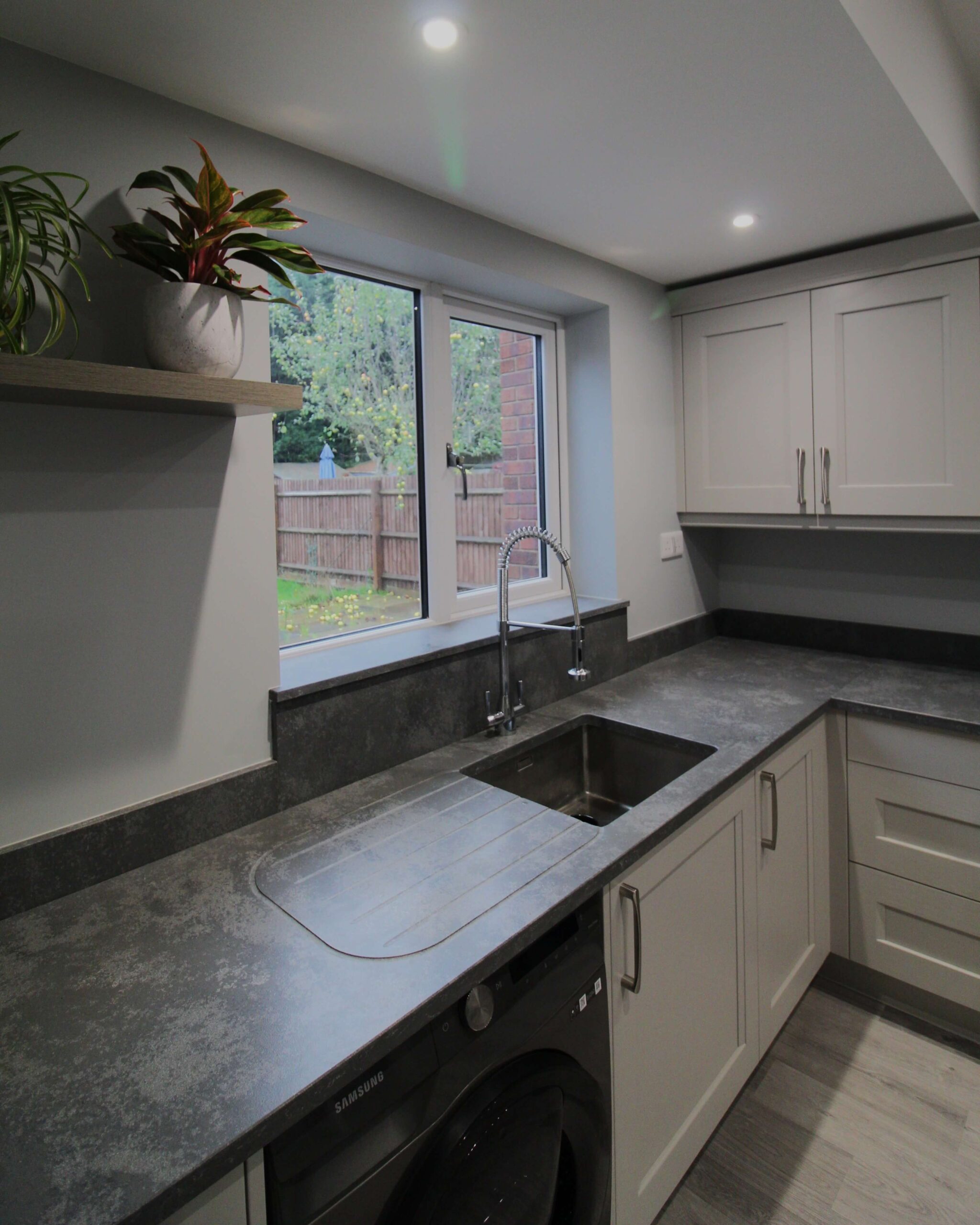 soft grey shaker kitchen with concrete quartz worktop and stainless steel sink and chrome tap