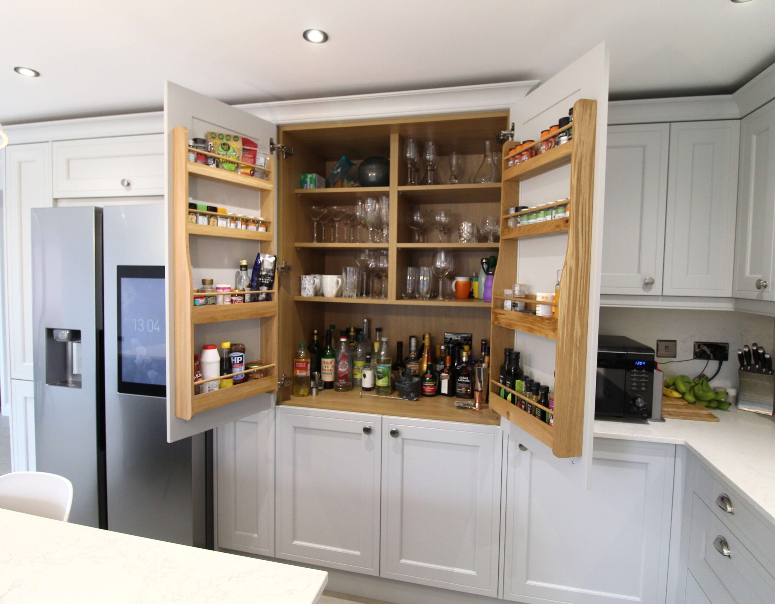 Light grey larder unit showcasing oak spice racks